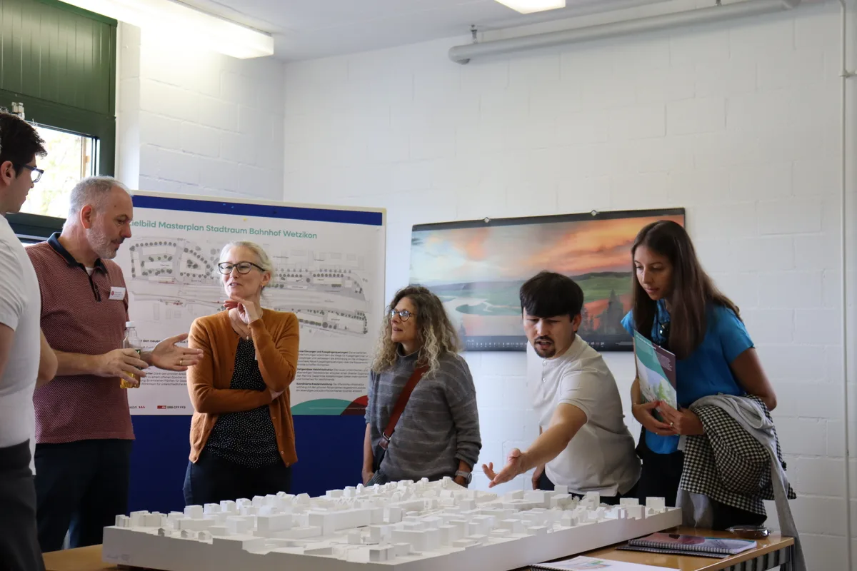 Menschen schauen das Modell des Bahnhofs an